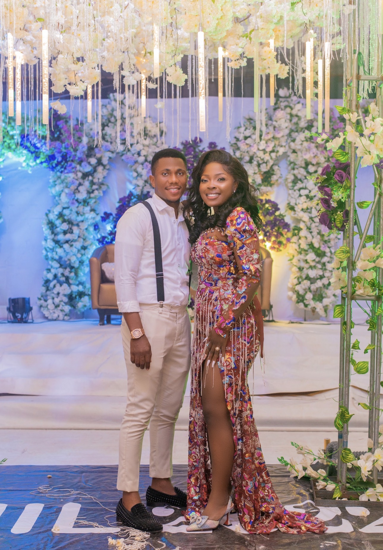Couple posing in front of floral installation